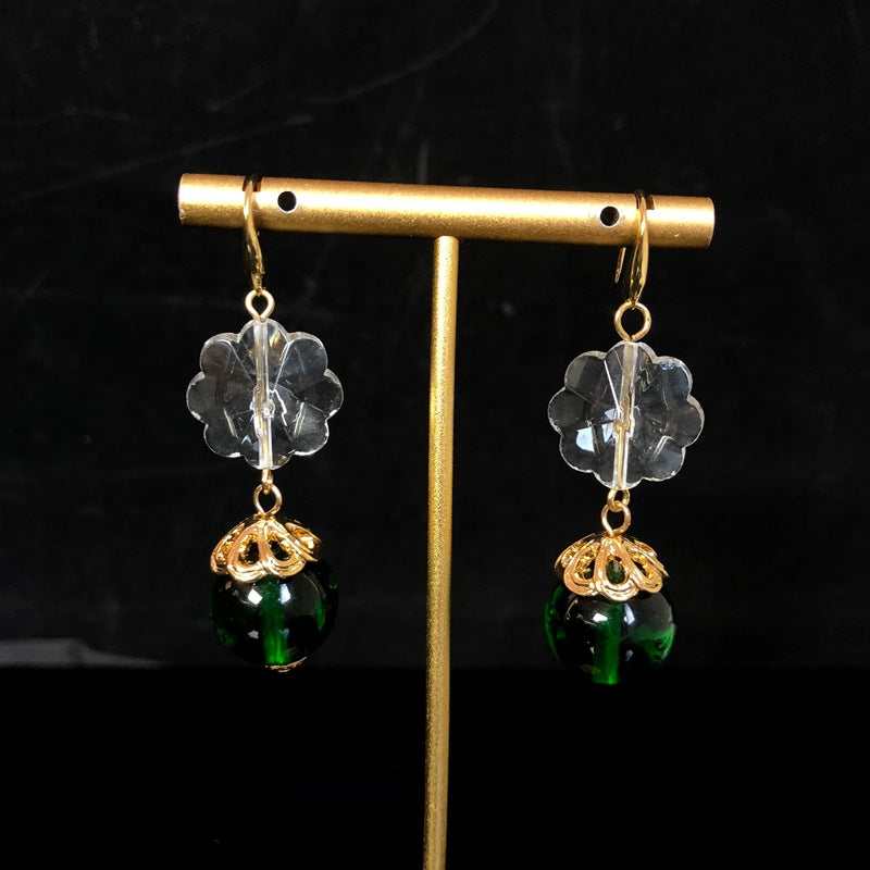 Stylish and elegant necklace and earrings featuring a design-forward, gold-plated finish, with delicate glass beads and faceted transparent glass beads