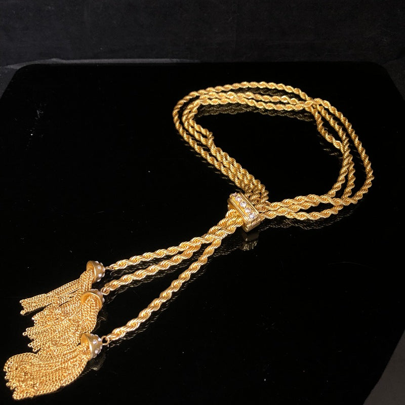 Hong Kong-style, personalized, trendy, minimalist jewelry with diamond accents, featuring a geometric double-layer twisted chain design, a simple gold finish, and a fashionable tassel