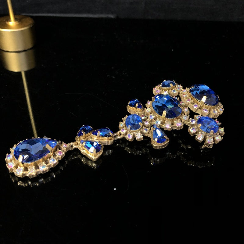 Vintage-style, exquisite, and luxurious brooch with diamond accents, featuring a classic design, a blue hue, and a sophisticated aesthetic, with copper settings and an aged finish