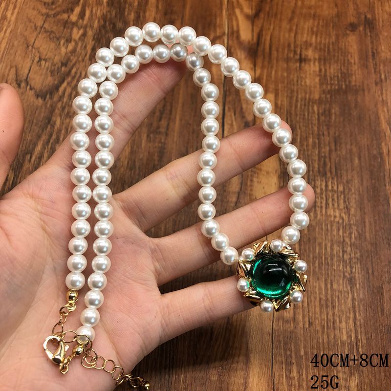 Vintage jewelry design, versatile pearl necklace with a green pendant, earrings, and a set of accessories – simple and stylish