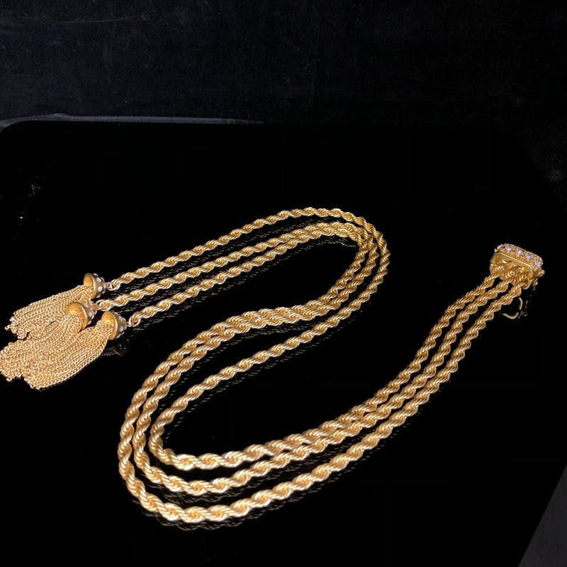 Hong Kong-style, personalized, trendy, minimalist jewelry with diamond accents, featuring a geometric double-layer twisted chain design, a simple gold finish, and a fashionable tassel