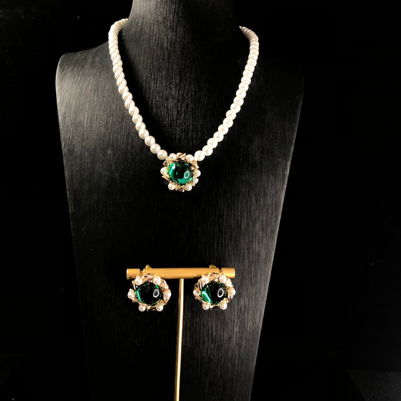 Vintage jewelry design, versatile pearl necklace with a green pendant, earrings, and a set of accessories – simple and stylish
