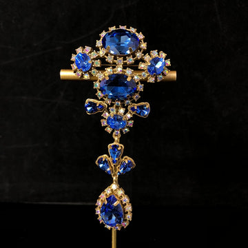 Vintage-style, exquisite, and luxurious brooch with diamond accents, featuring a classic design, a blue hue, and a sophisticated aesthetic, with copper settings and an aged finish