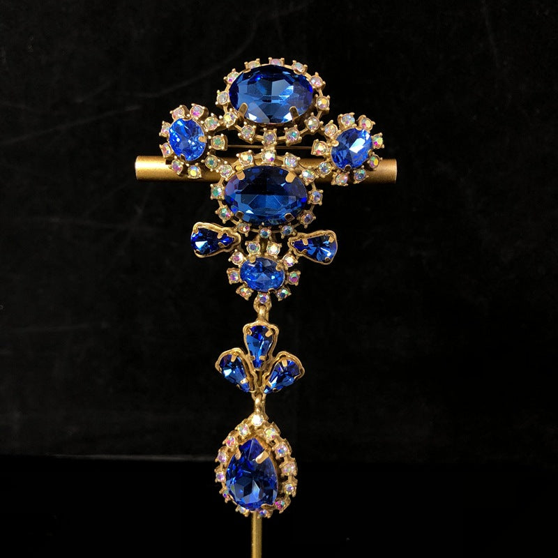 Vintage-style, exquisite, and luxurious brooch with diamond accents, featuring a classic design, a blue hue, and a sophisticated aesthetic, with copper settings and an aged finish