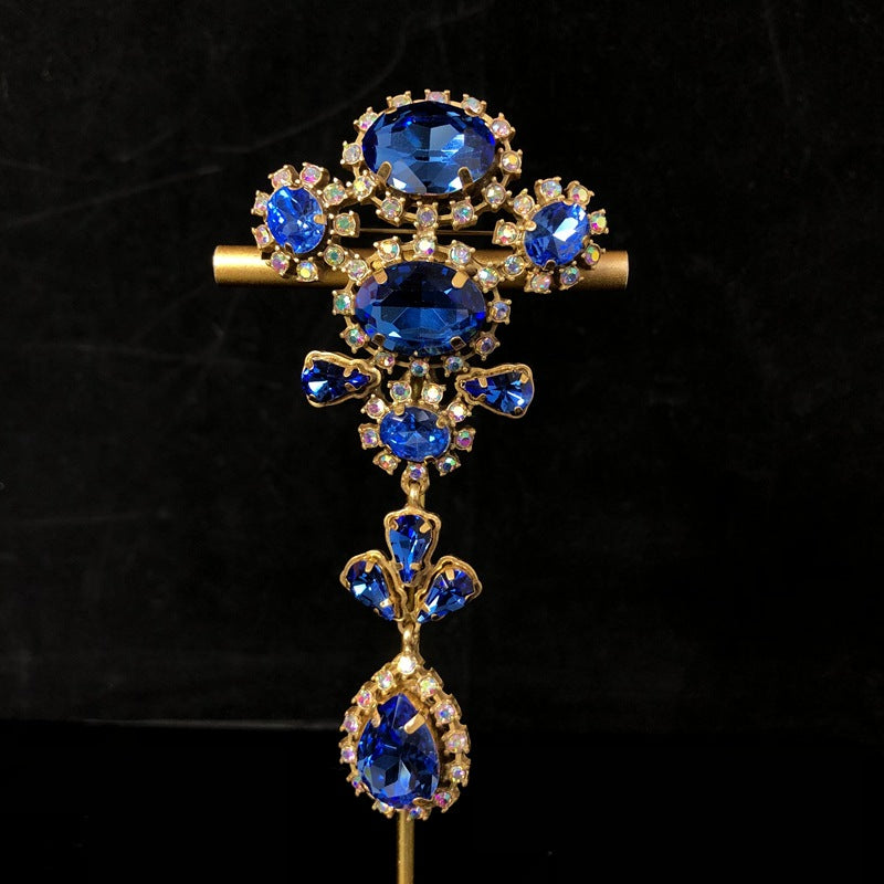 Vintage-style, exquisite, and luxurious brooch with diamond accents, featuring a classic design, a blue hue, and a sophisticated aesthetic, with copper settings and an aged finish