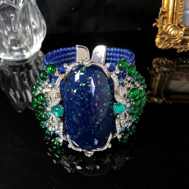 Vintage-style, intricately crafted blue beaded bracelet with rhinestone and green jelly resin accents, a fashionable wrist accessory