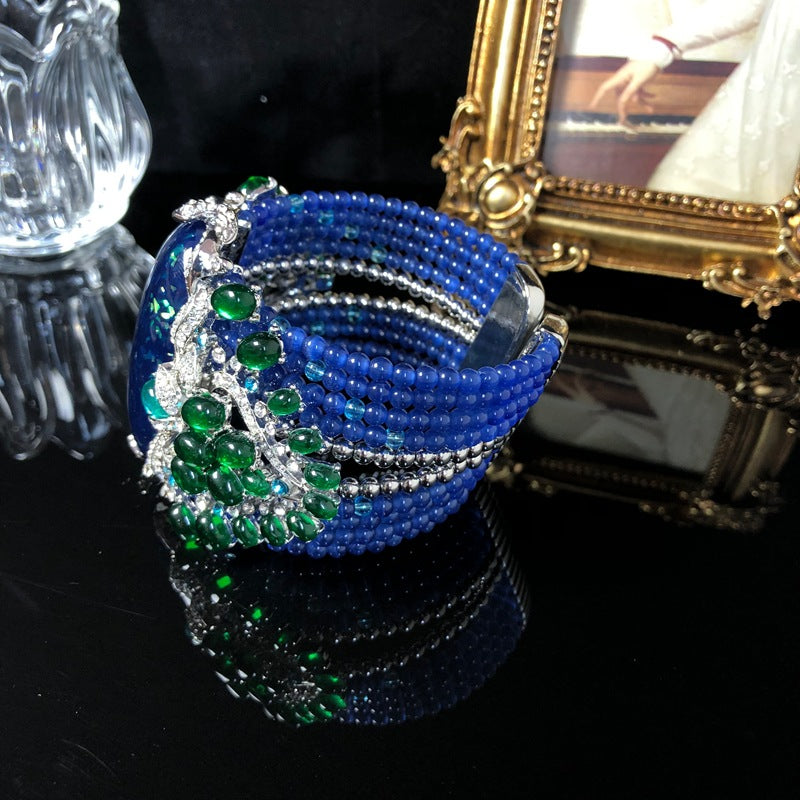 Vintage-style, intricately crafted blue beaded bracelet with rhinestone and green jelly resin accents, a fashionable wrist accessory