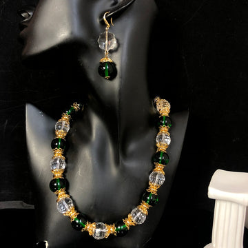 Stylish and elegant necklace and earrings featuring a design-forward, gold-plated finish, with delicate glass beads and faceted transparent glass beads