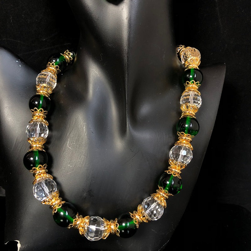 Stylish and elegant necklace and earrings featuring a design-forward, gold-plated finish, with delicate glass beads and faceted transparent glass beads