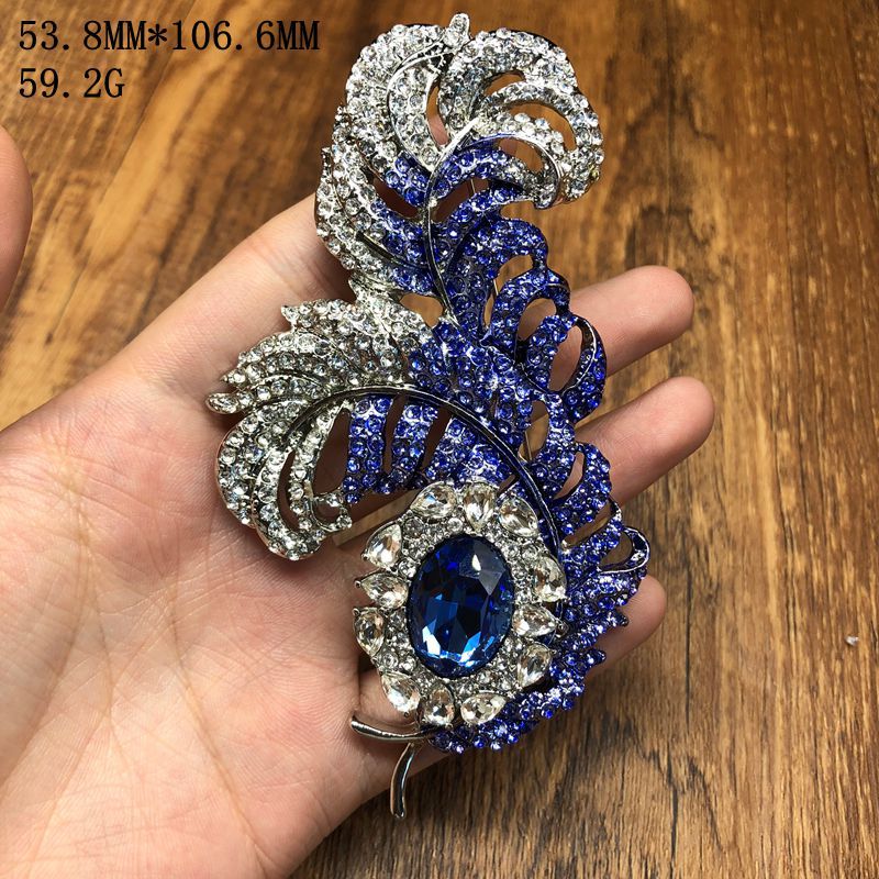 Retro palace-style design, feather-shaped, blue diamond accents, lightweight luxury, high-end, fashionable brooch, elegant, stylish, and unique