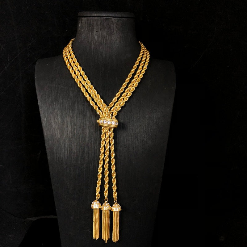 Hong Kong-style, personalized, trendy, minimalist jewelry with diamond accents, featuring a geometric double-layer twisted chain design, a simple gold finish, and a fashionable tassel
