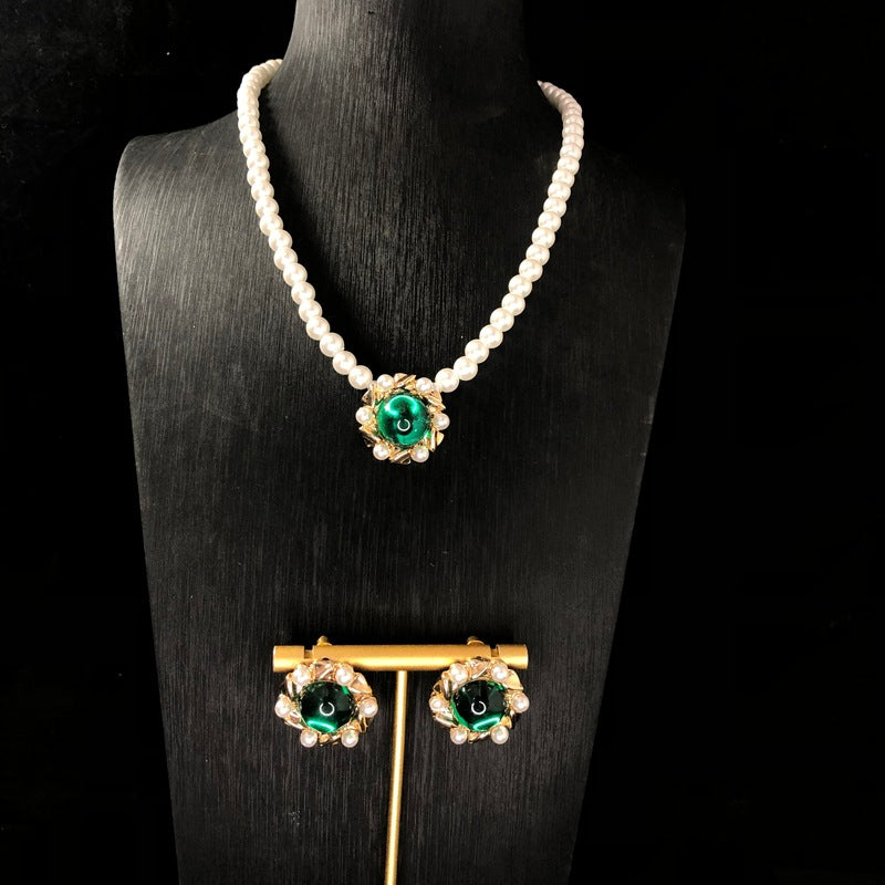 Vintage jewelry design, versatile pearl necklace with a green pendant, earrings, and a set of accessories – simple and stylish