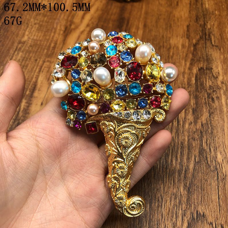 Vintage jewelry design, fashionable and versatile, exquisite hollowed-out design with diamond and pearl embellishments, elegant floral carving, and a sophisticated brooch